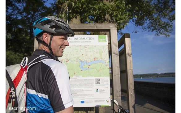 Radfahrer vor Knotenpunktkarte am Möhnesee